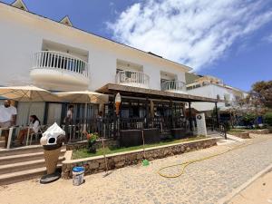 a building with people sitting outside of it at Top Leme Bedje in Santa Maria