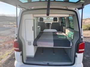 an open van with a bed in the back at Nomad Campers VW California in La Mareta