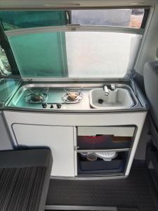 a kitchen with a stove and a sink at Nomad Campers VW California in La Mareta