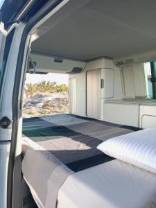a bed in the back of a camper van at Nomad Campers VW California in La Mareta
