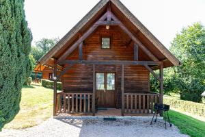 a log cabin with a front door and a chair at Domaine Guillaume Chalet 6p classic in Auquainville