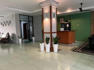 a lobby with potted plants on a tile floor at Emerald hotel in Jomtien Beach +100 photos
