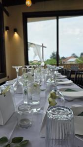 a long table with white plates and glasses on it at Vino & Vista in Ripanj