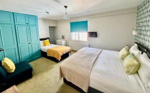 a bedroom with two beds and a blue cabinet at Dream Stays Bath - Trim Street Townhouse with Hot tub in Bath