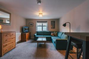 a living room with a blue couch and a television at Home Farm & Lodge in Bawtry