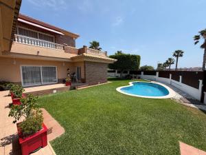 a backyard with a swimming pool and grass at Blended in Calafell
