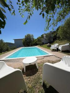 a swimming pool with chairs and a table next to it at Aire de las Sierras in Embalse