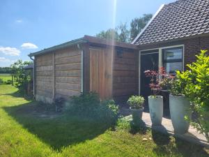 ein kleiner Holzschuppen mit Pflanzen in einem Garten in der Unterkunft Erve Boonk in Neede