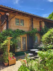 a wooden house with a table and a patio at Le chalet caché, au pied des Chambarans in Saint-Siméon-de-Bressieux