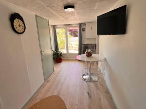 a hallway with a table and a clock on a wall at Appartement causy in Gonfreville-lʼOrcher