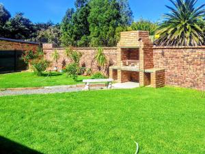 a garden with a bench and a brick wall at Schweizer Lodge in Schweizer-Reineke