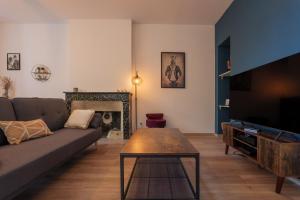 a living room with a couch and a table and a tv at T4 Cosy - Château - Wifi in Aubenas