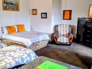 a living room with two beds and a chair at Schweizer Lodge in Schweizer-Reineke