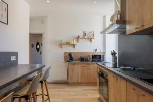 a kitchen with wooden cabinets and a counter top at T4 Cosy - Château - Wifi in Aubenas