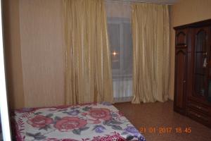 ヴォログダにある2 Rooms Gagarin apartamentsのベッドルーム1室(ベッド1台、ドレッサー、窓付)