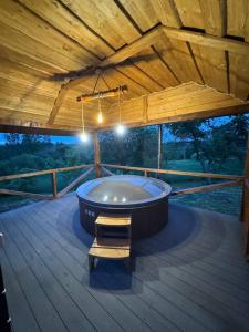 a bath tub on a deck with a wooden ceiling at Садиба Сенчина in Utoropy