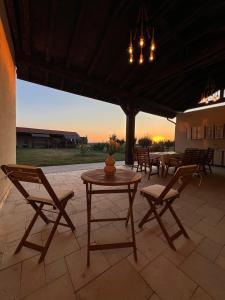 a patio with a table and chairs and a chandelier at Colt de Apuseni in Curăţele