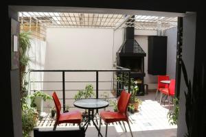 a balcony with a table and chairs and a stove at Go Hostel in Córdoba