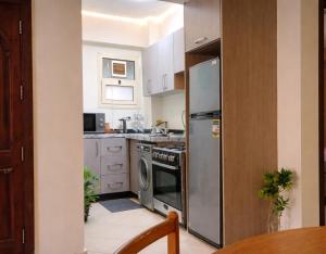 a kitchen with a stainless steel refrigerator and a dishwasher at Casa Dòdò - Sunny Lakes Compound in Sharm El Sheikh