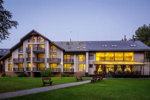 a large building with benches in front of it at Viešbutis "Linelis" in Paplatelė