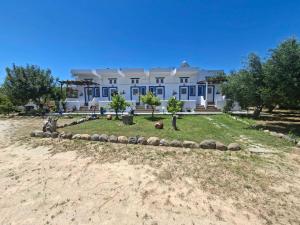 a large white house on a beach with a yard at Nefeli Apartments in Kefalos