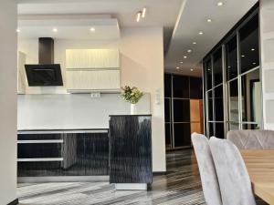 a kitchen and dining room with a table and chairs at Apartament SPACE & SUN z wewnętrzym ogrodzonym parkingiem in Toruń +19 photos