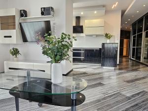 a living room with a glass table with a vase of flowers at Apartament SPACE & SUN z wewnętrzym ogrodzonym parkingiem in Toruń