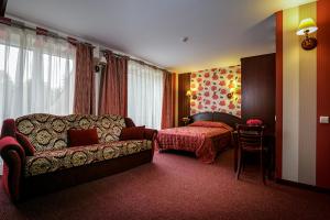 a hotel room with a couch and a bed at Viešbutis "Linelis" in Paplatelė +14 photos