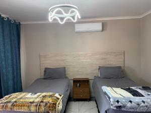 a bedroom with two beds and a chandelier at Northam Square Mine Contractor Accommodation in Northam +47 photos