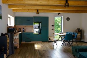 a kitchen with blue cabinets and a table with chairs at Chata Vali in Loučovice