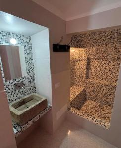 a bathroom with a sink and a shower with a mirror at La casa di Mastro Ivetto in Arcevia
