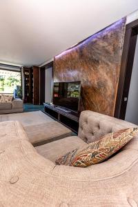 a living room with a couch and a large screen at Breite Privée Forest and Pool Retreat in Sighişoara +40 photos