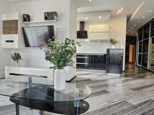 a living room with a glass table and a kitchen at Apartament SPACE & SUN z wewnętrzym ogrodzonym parkingiem in Toruń