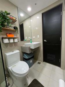 a bathroom with a toilet and a sink and a mirror at Gabbys Place in Bacolod +29 photos