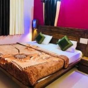 a large bed in a room with pink walls at Hotel Green lotus villa mahabaleshwar in Mahabaleshwar +10 photos