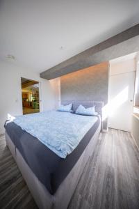 a bedroom with a large bed with a blue comforter at Beim alten Forsthaus in Zella-Mehlis
