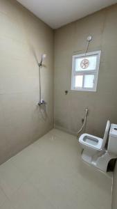 a bathroom with a toilet and a window at The Inn Salalah in Salalah