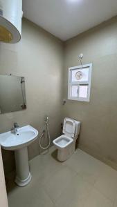 a bathroom with a sink and a toilet and a window at The Inn Salalah in Salalah
