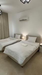 two beds in a white room with at The Inn Salalah in Salalah
