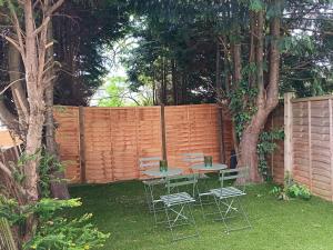a table and chairs in a backyard with a fence at Large 6 Bed 6 Bathroom House - Ideal For Families, Large Groups, Contractors & Business Travellers in Watford