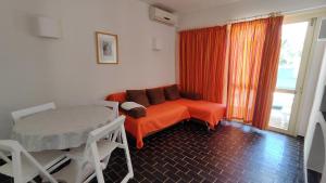 an orange couch in a room with a window at Balaia Gardens, jardins da Balaia in Albufeira