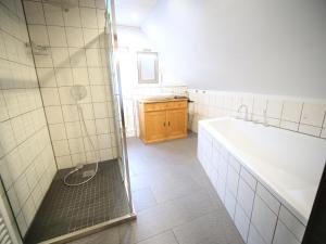 a bathroom with a shower and a tub and a sink at Albsteig-Apartments Gruibingen in Gruibingen