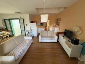 a living room with a couch and a tv at Satiria residence ML in Metaponto