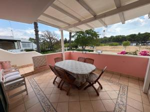 a patio with a table and chairs on a balcony at Satiria residence ML in Metaponto