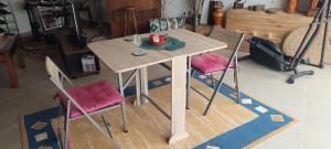 a wooden table with two chairs and a table with a cup at Kyrios Lounge Studio with use of private pool in Carrascal