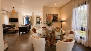 a living room with a glass table and chairs at Themis Luxury Private Villa Rhodes with Private Pool in Ialysos +32 photos