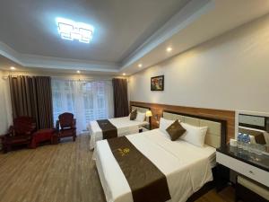 a hotel room with two beds and a television at G9 home hotel in Hanoi +33 photos