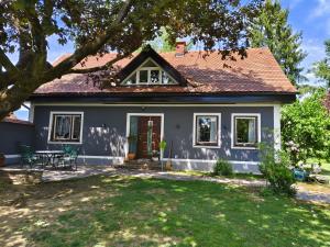 a white house with a tree and a yard at Ferienhaus Wurzinger in Mureck