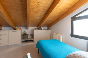 a bedroom with a blue bed and a window at Lefkada Town Condo in Lefkada