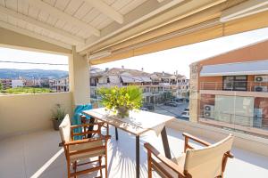 a balcony with a table and chairs and a large window at Lefkada Town Condo in Lefkada